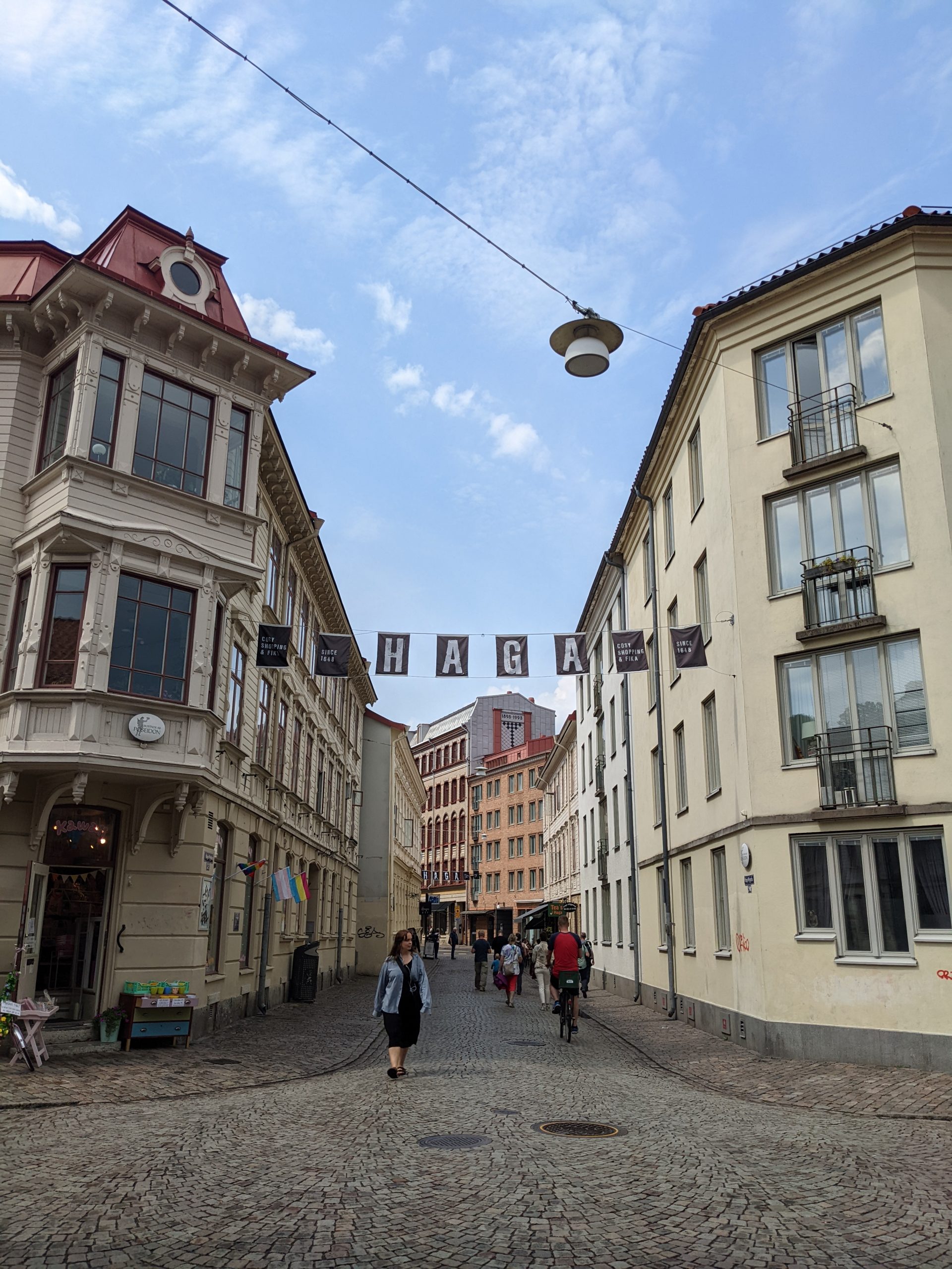 A old city with a banner that says HAGA strung between the buildings