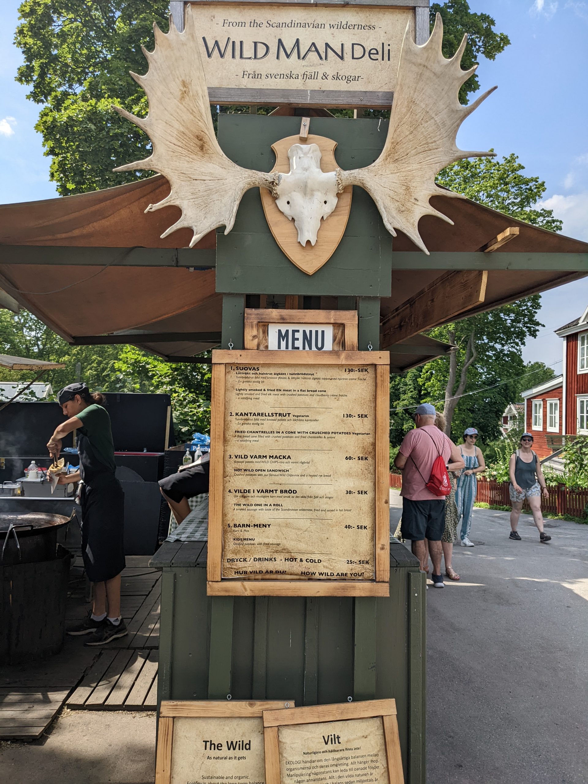 A stall named Wild Man Deli with a menu