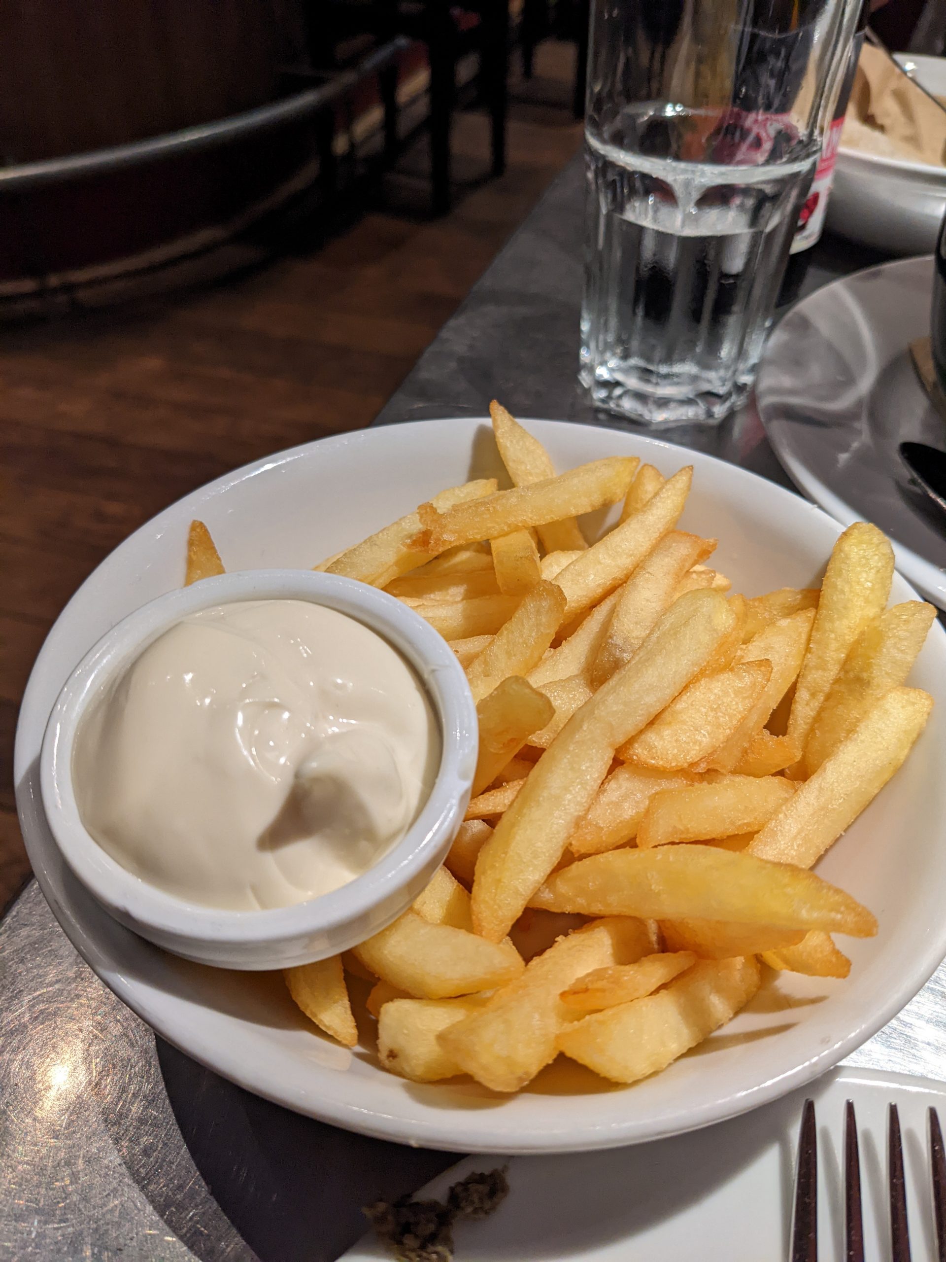 Bowl of fries with a small container of mayonnaise